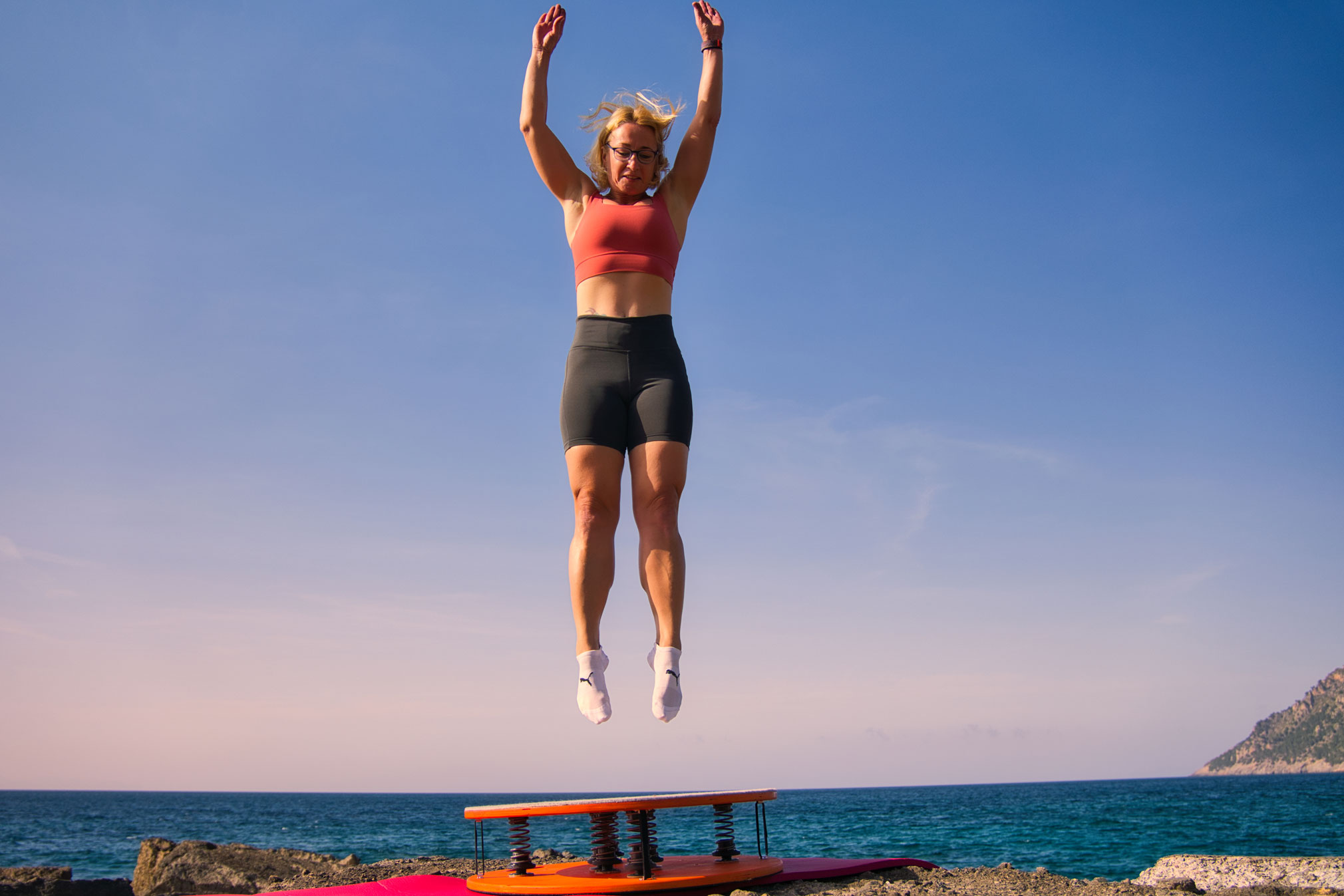 Iris springt auf Mallorca vor dem Meer über dem Jumpmaster